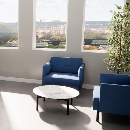 A cozy room featuring a blue couch paired with a white table, creating a stylish and inviting atmosphere.